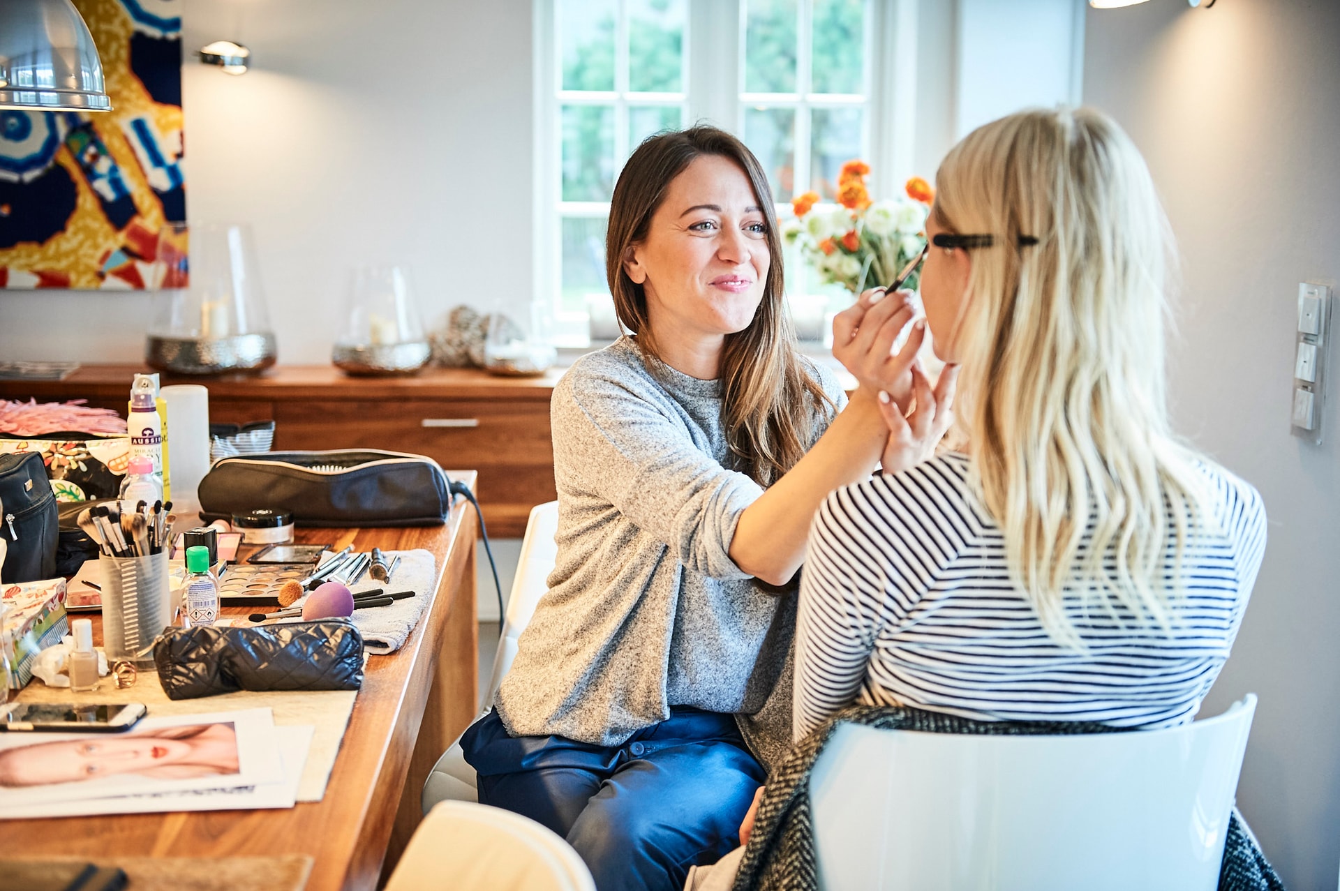 Make-up artist Anja Fichtenmayer preparing a woman for a Burda editorial shoot on Sylt, photographed by Astrid M. Obert.